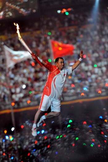 Digital photograph of torch bearer aloft in Beijing stadium