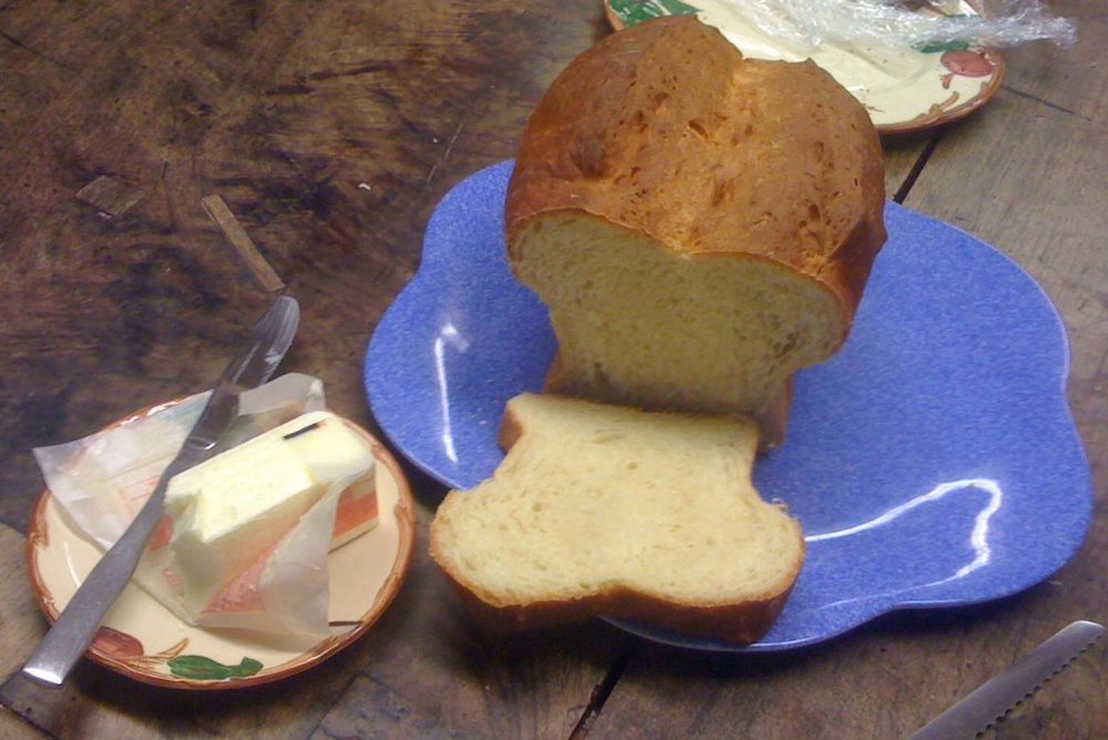 A sliced-open loaf of bread on a blue plate.