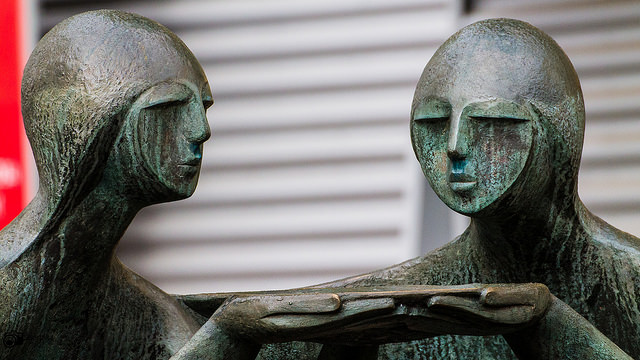 Two statues jointly holding a plate