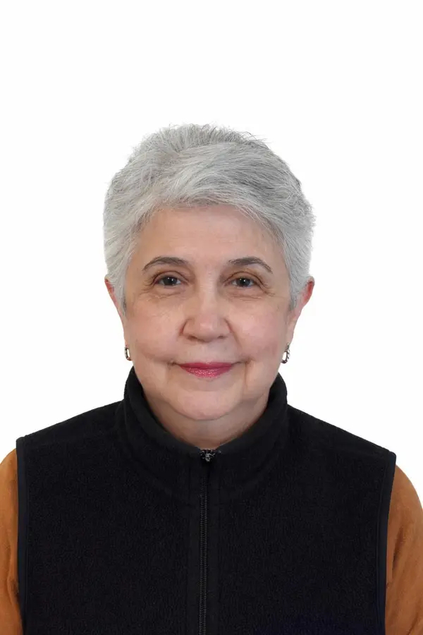 Photo of an older woman with short gray hair wearing a black sleeveless turtleneck.