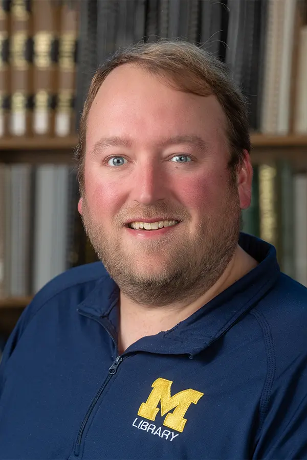 image of Gregor Langbehn, a tall white man with blondish hair and a beard wearing a blue U-M Library polo shirt
