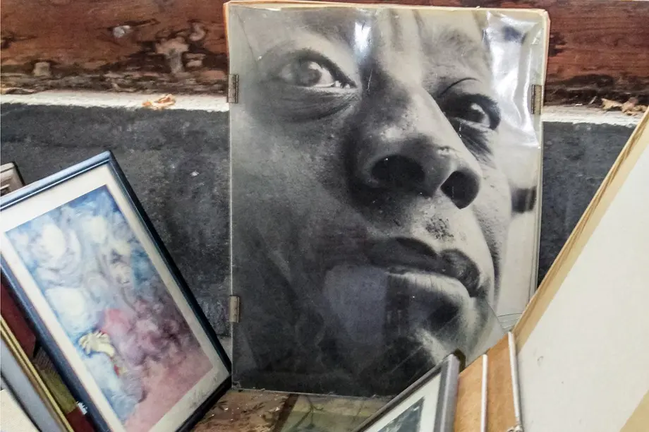 Part of a wooden box containing a portrait of a black man along with framed artwork.