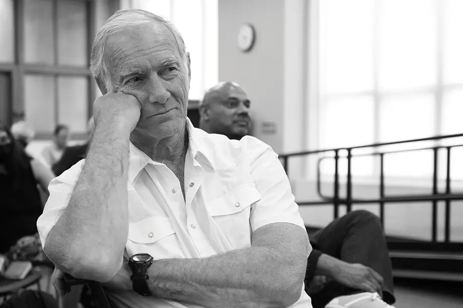 Director John Sayles, sitting in the Hatcher Library Gallery and propping his head on his fist.