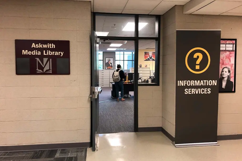 Entrance to the Askwith Media Library, with a sign to the left of the door, and a tall banner that says "Information Services" on the right.