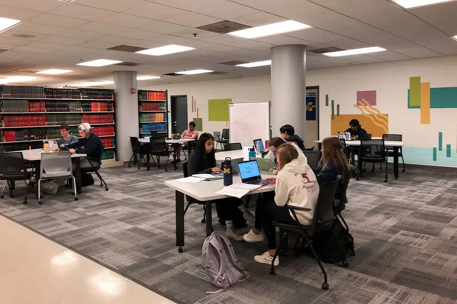 Students studying at tables in the basement of the Shapiro Library