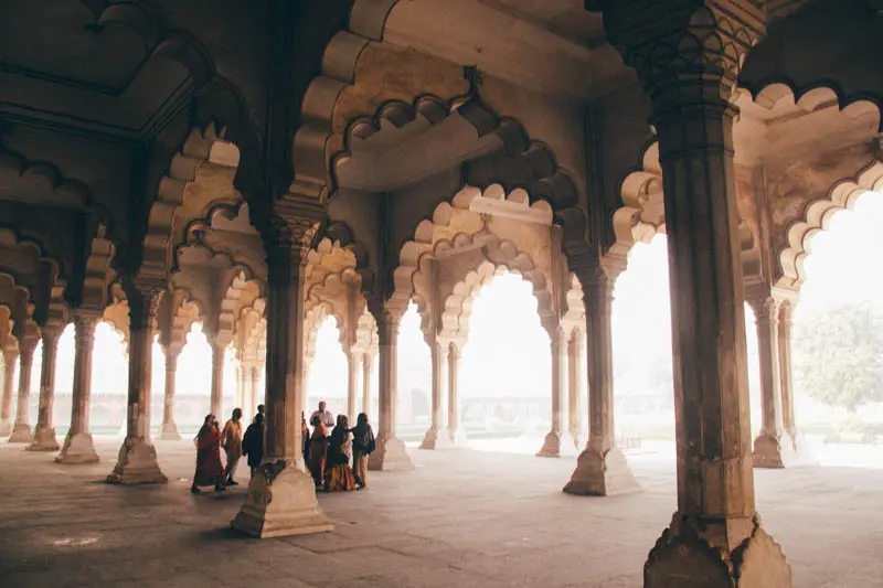 Group of people gathered in a temple during the day in India.