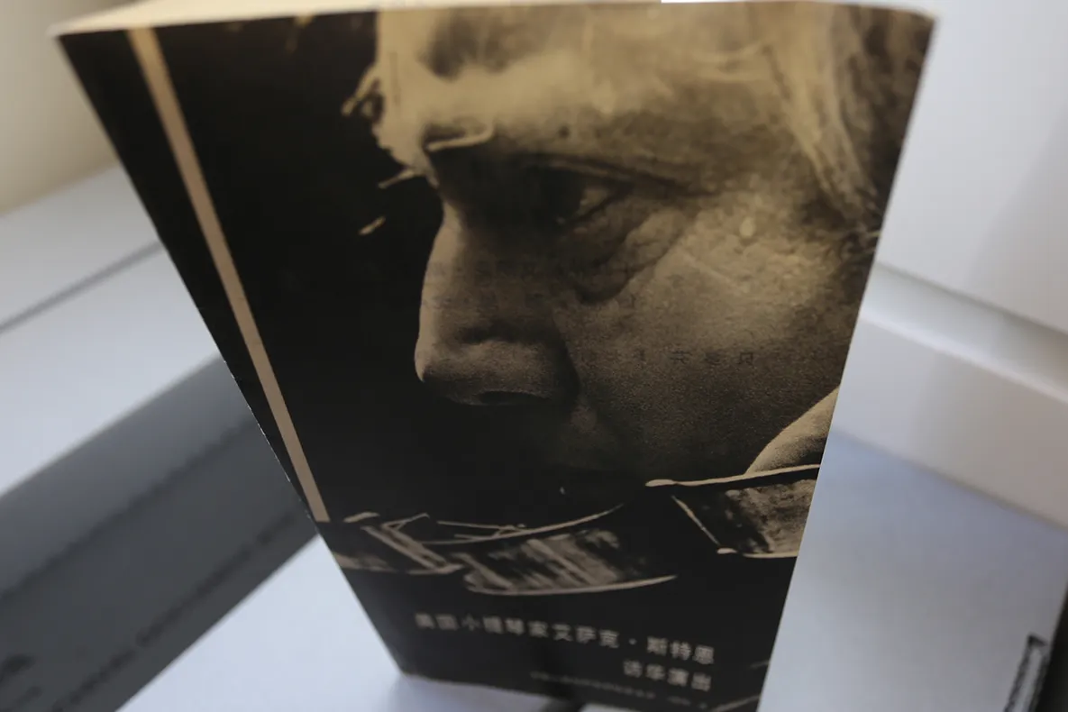 Front cover of an event program with the profile of an older white man and Chinese characters.