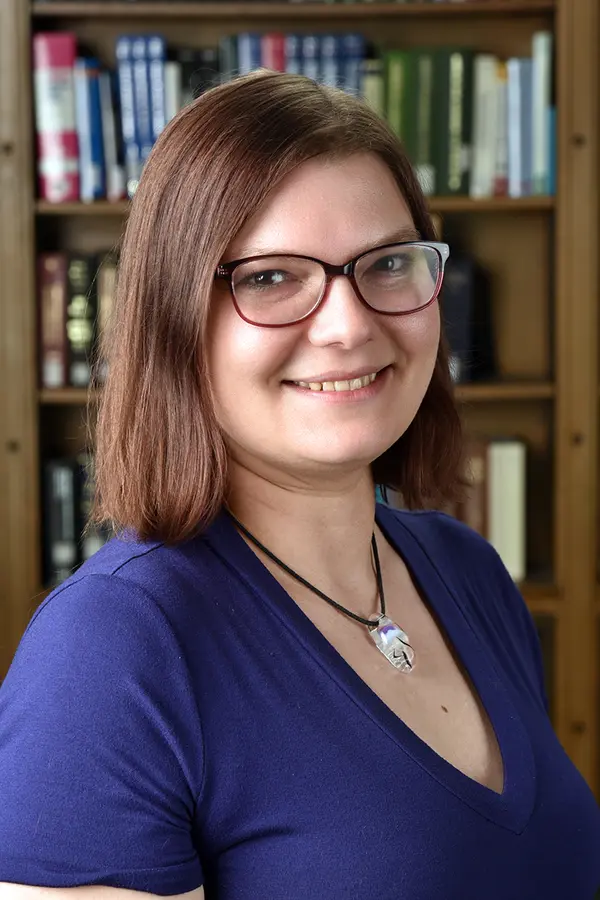 Photograph of Kathryn Vanderboll, a white woman with glasses and shoulder-length red hair.