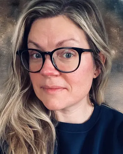 Self-portrait of Bridget Burke, a white person with brown and blonde hair and dark glasses