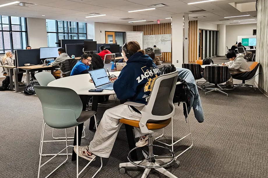 Students working at tables with extended display monitors