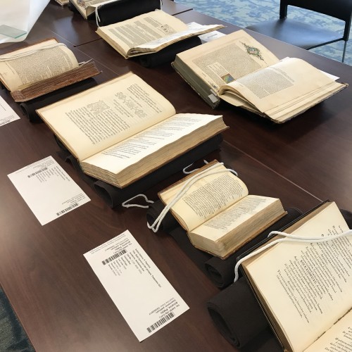 manuscripts and printed books displayed open on a table