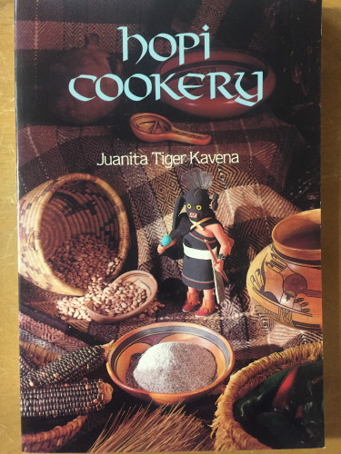 front cover of Hopi Cookery, depicting a small figure perched among bowls, baskets, and recipe ingredients