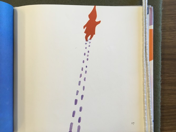 page from The Snowy Day depicting a small child walking through the snow with a long trail of footprints