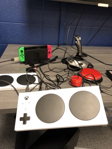Photo of multiple adaptive controllers, including an XBox adpative controller, Nintendo Switch, and joystick
