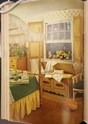Bedroom decorated in yellow and green: yellow checked curtains set in wooden shutters, a yellow, green and white canopied bed, and a wooden chest storing yellow and white linens. 