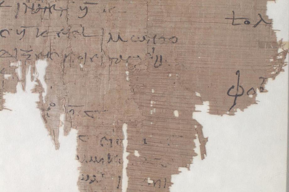 A fragment of ancient papyrology that is frayed around the edges with writing visible on it