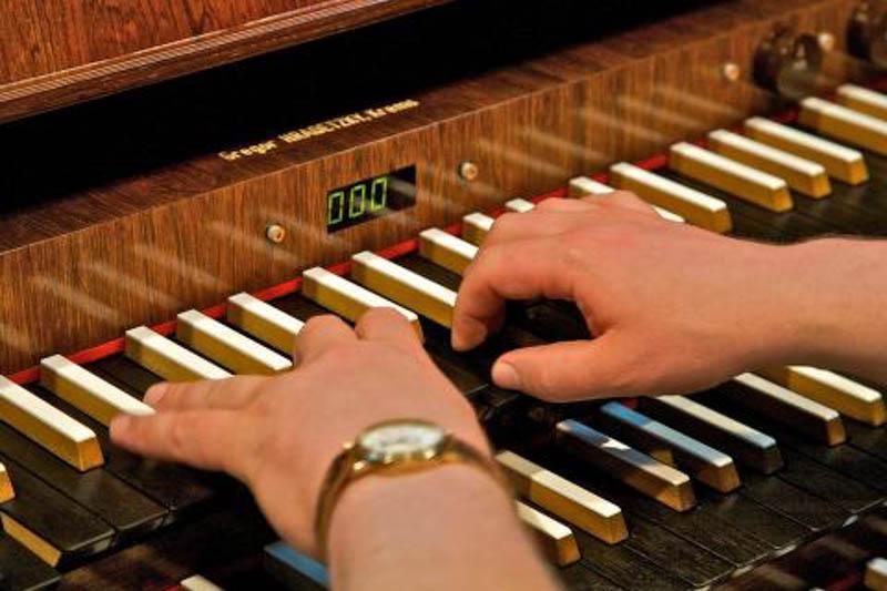 Close-up image of hands playing the organ.