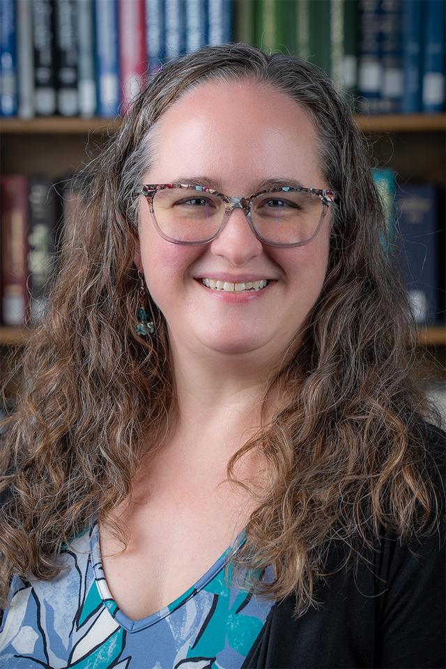 Photo of Sara Samuel, a white woman with long wavy light brown hair and glasses.