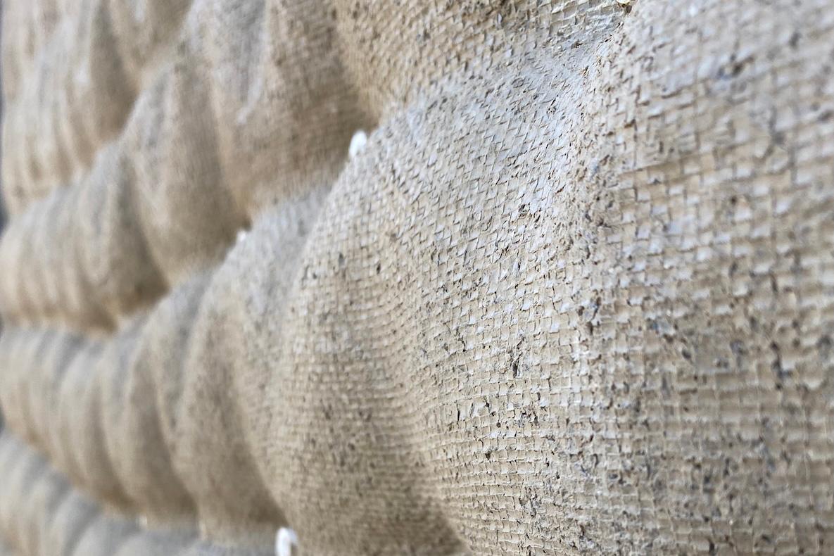 A section of a textured wall structure in an ecru color.