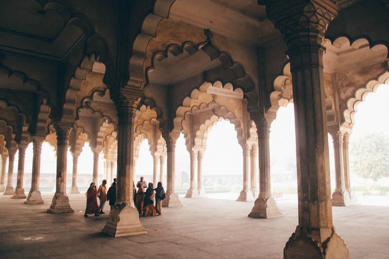 Group of people gathered in a temple during the day in India.