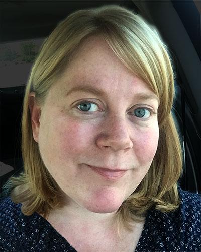 Photograph of Robyn Ness, a white woman with blond hair. This is a casual headshot with a dark background.