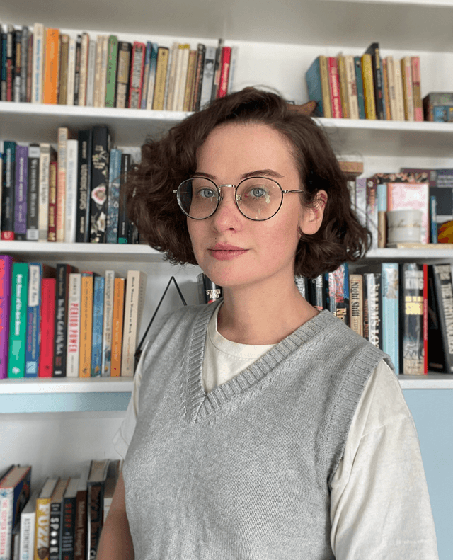 Marisa Mercurio in front of a bookshelf.