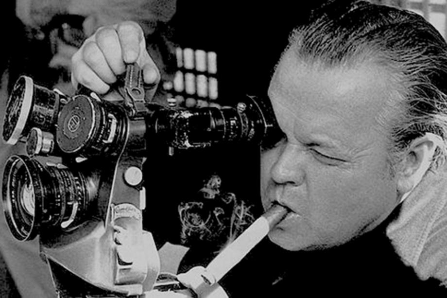 man with a cigar in his mouth looking into a camera viewfinder