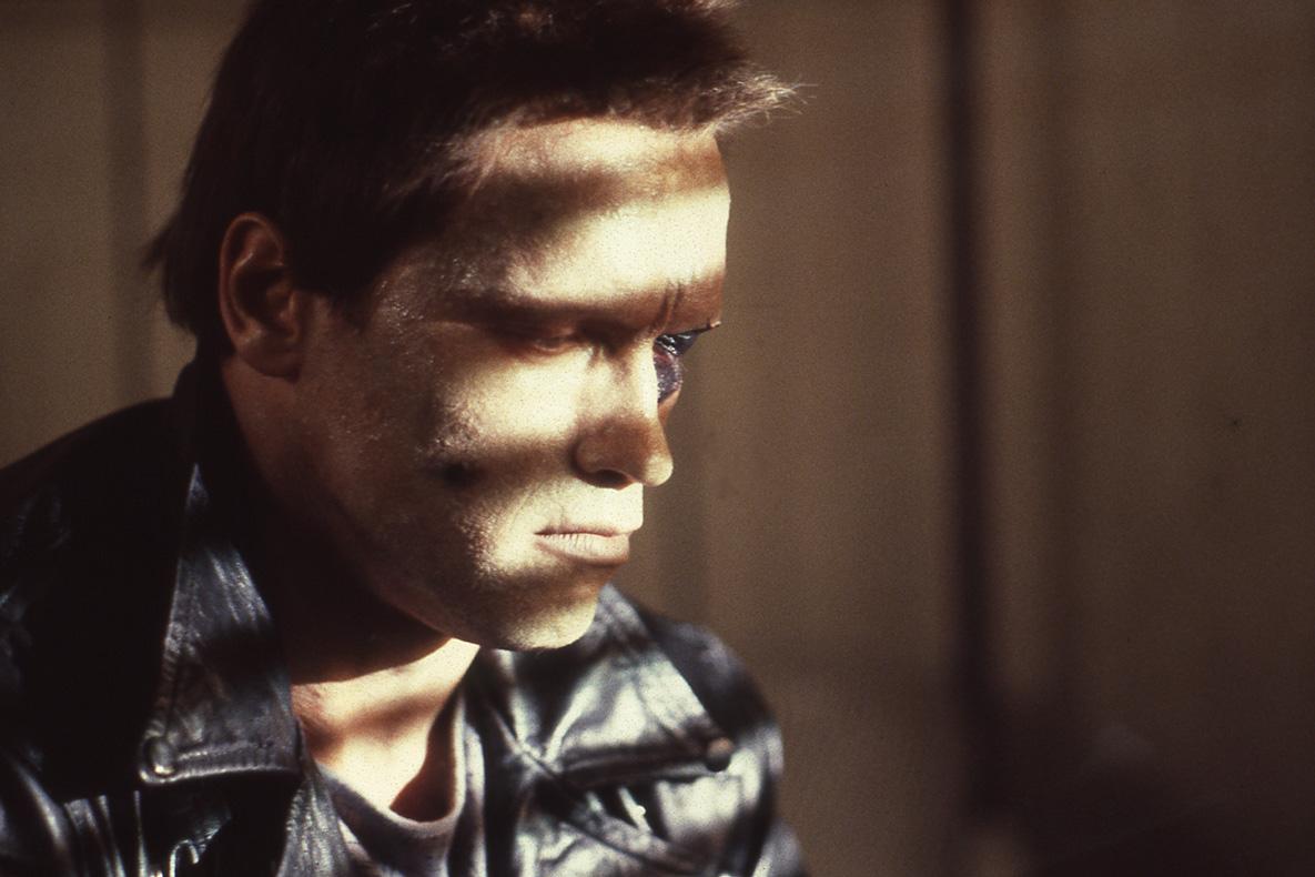 A man's face in semi profile, with shadows across it, and the far eye looking damaged.