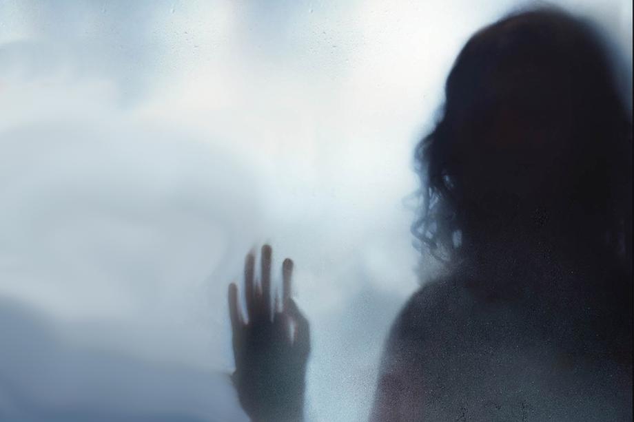 Spooky, foggy image of the back of a woman's head and hand.