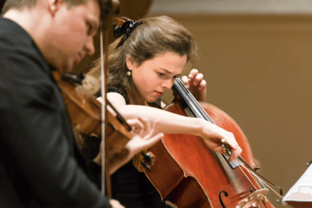 Man playing a violin and a woman playing a cello.