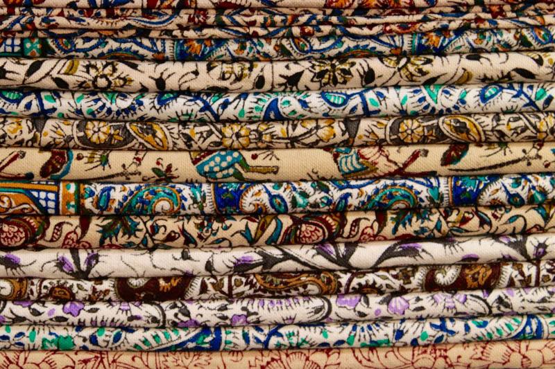 Stack of colorful textiles in an Isfahan bazaar.