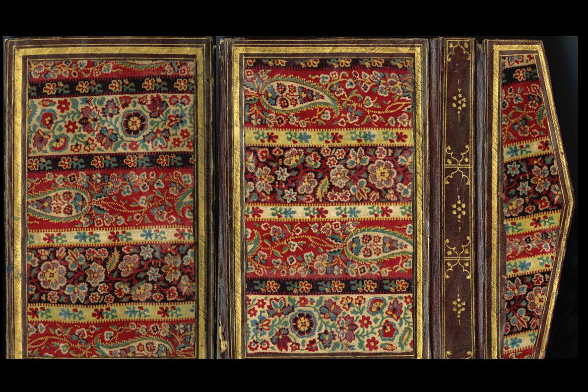 Rectangular covers and pentagonal flap with bands of colorful floral vegetal designs surrounded by brown leather frame borders.