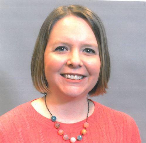 Photograph of Joanna Thielen , a young, white woman, wearing a peach sweater and a huge smile.